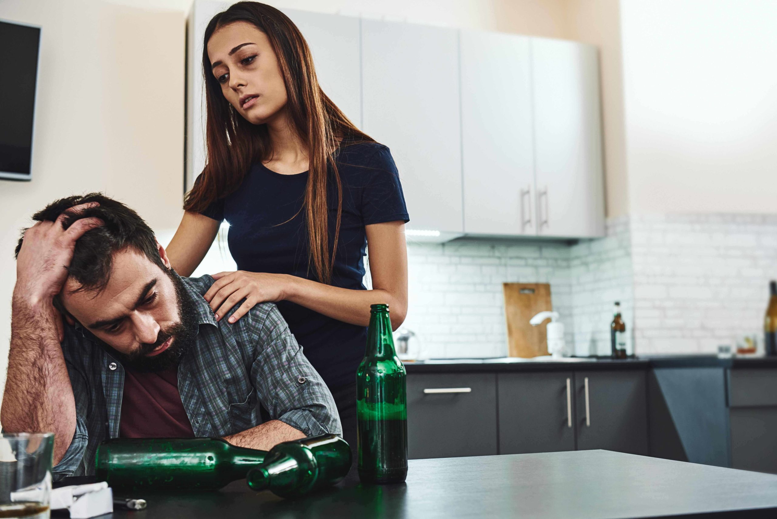 alcoholic man binge drinking with woman supporting him