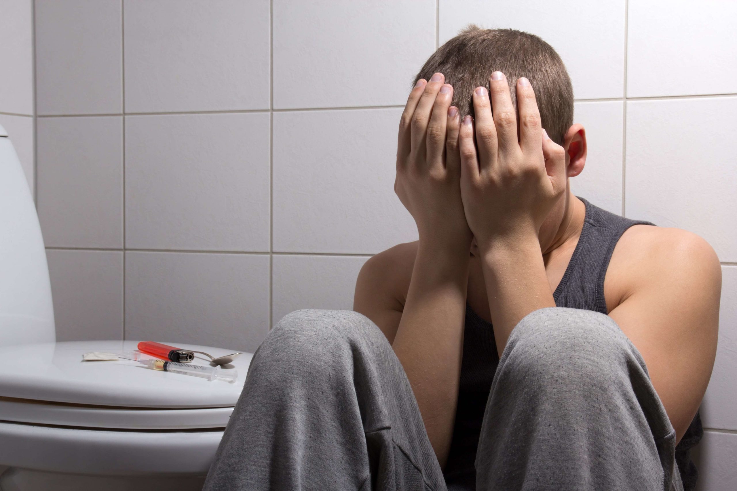 man in bathroom addicted to heroin