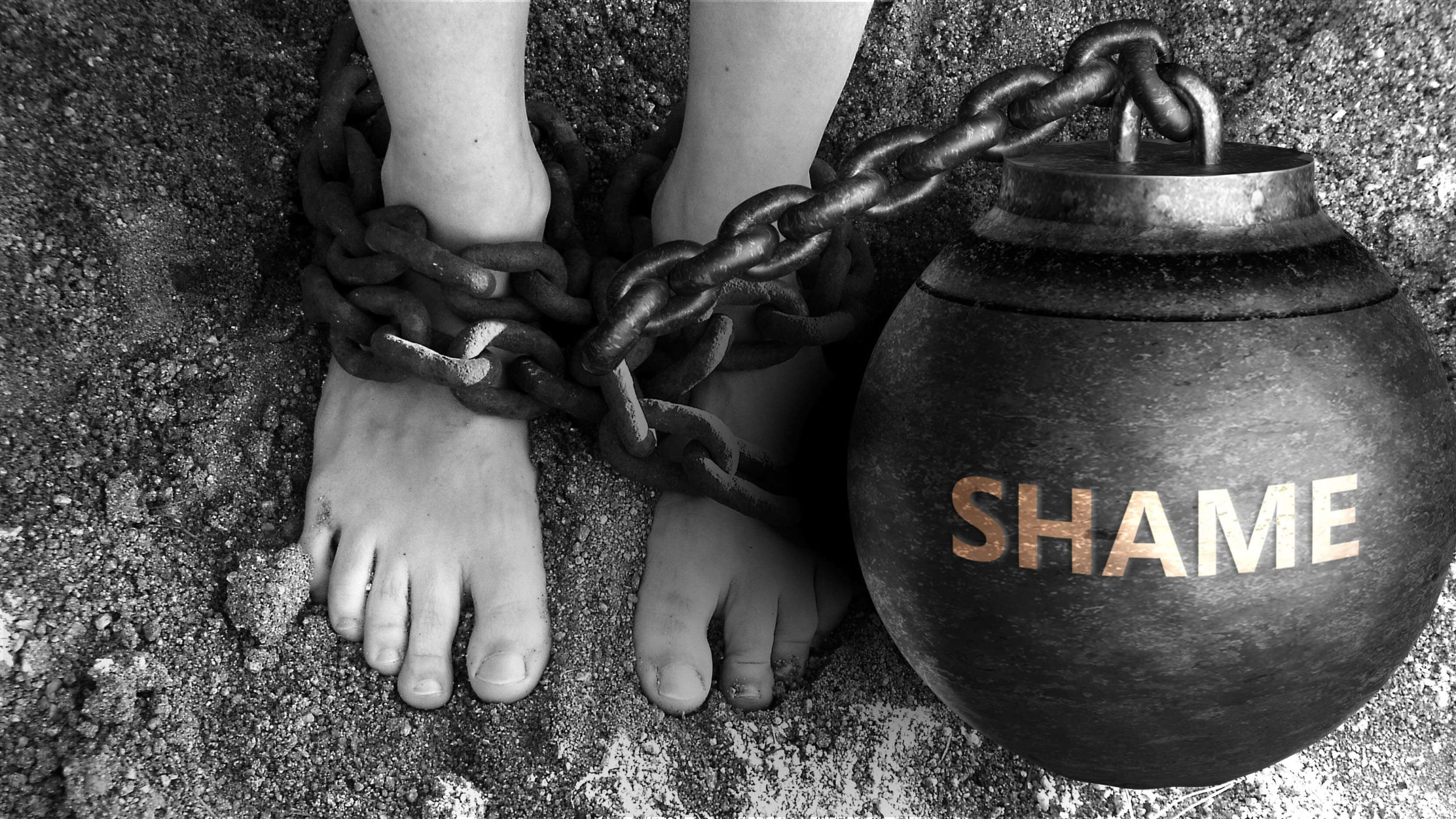 a person chained to a ball that says shame