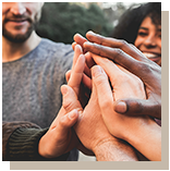 Group of people in circle putting hands in