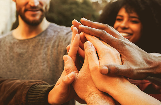 Circle of people putting their hands together