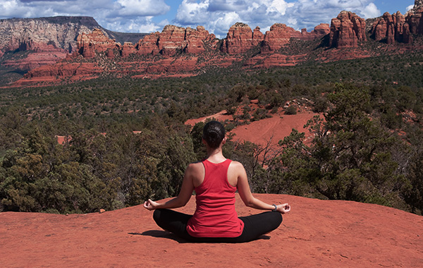 Woman doing yoga outdoors on red rocks