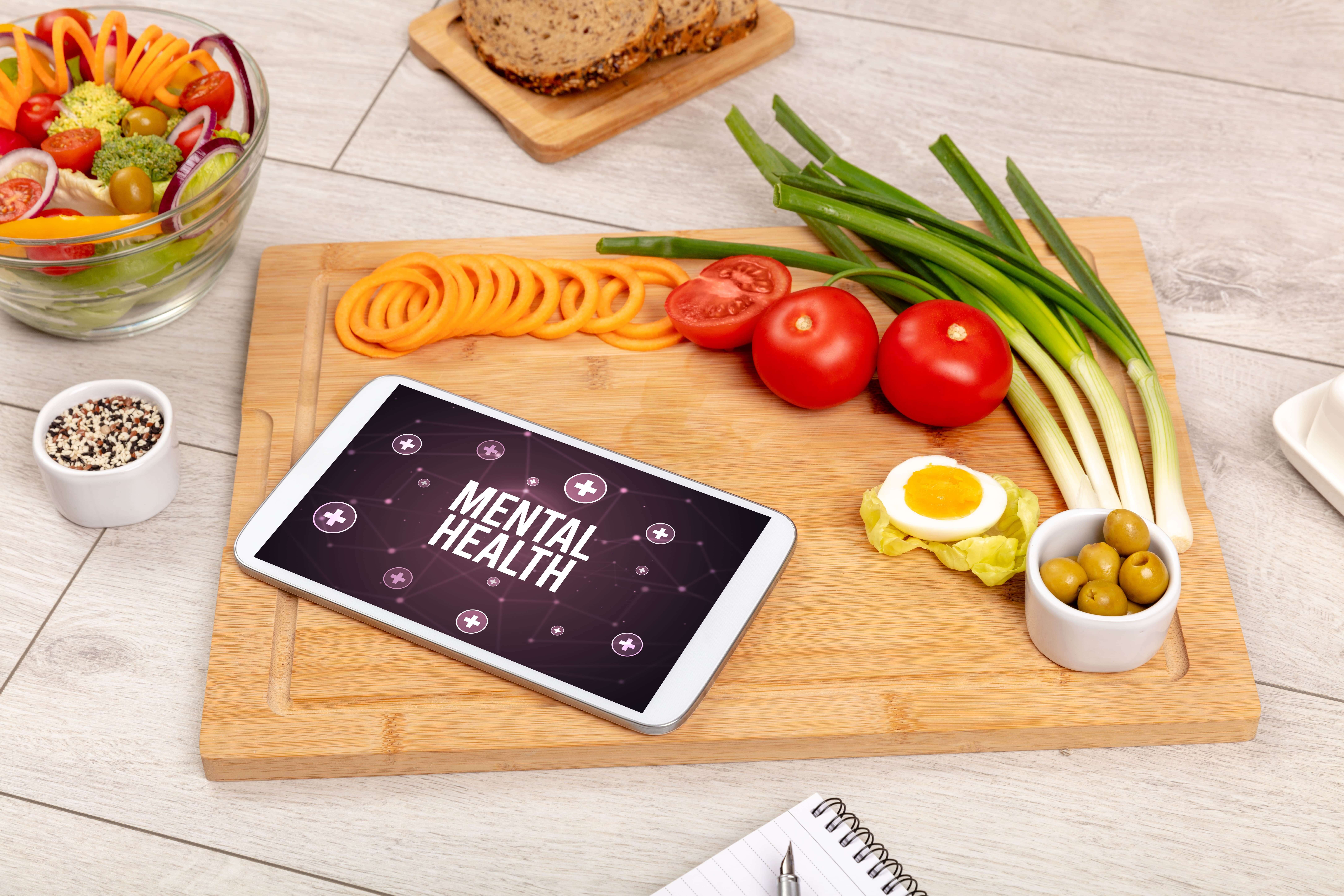mental health written on tablet next to healthy food